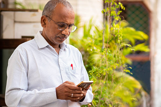 istock Portrait of middle aged man in eyeglasses using a smartphone in balcony. 2212773568