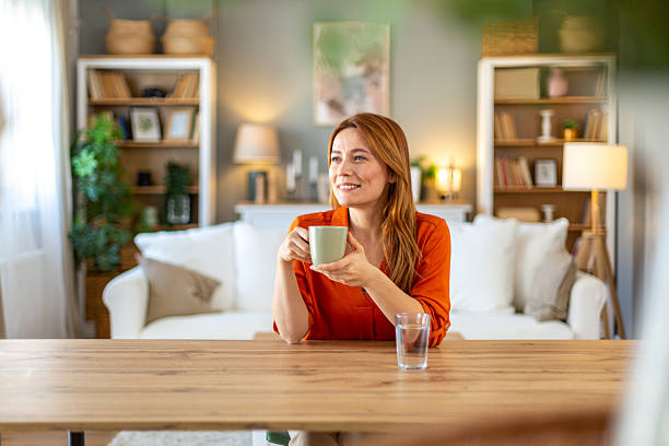 istock Serene woman relaxing with a warm beverage in her comfortable home 2212773952