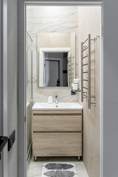 istock small bathroom with white sink, square mirror, cabinet under sink, chrome faucet. beige ceramic tiles on walls. Bathroom design in flat, hotel or apartment. 2212774167