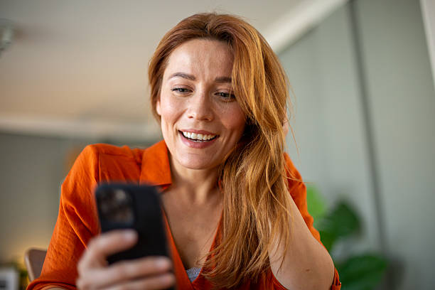 istock Happy woman using mobile phone at home smiling and browsing internet 2212776291