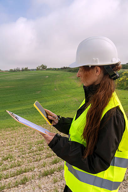 istock Female engineer inspecting green field for sustainable energy project 2212777663