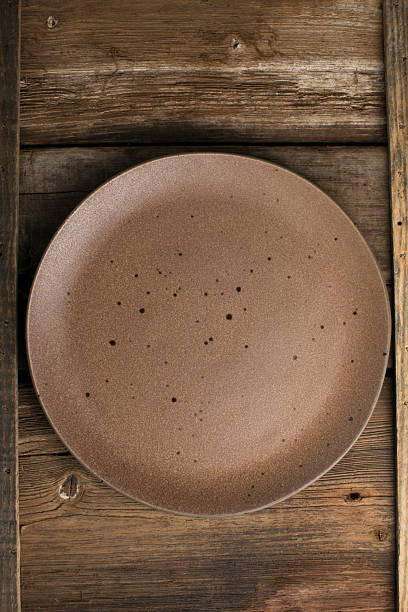 istock Empty brown plate on wooden table close up 2212778086