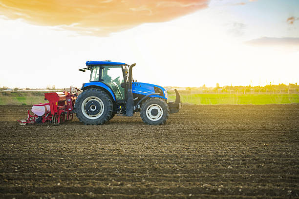istock A farmer sowing seeds with a tractor and seed drill in a field at sunset 2212782655