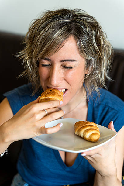 Woman enjoying a delicious pastry on white background