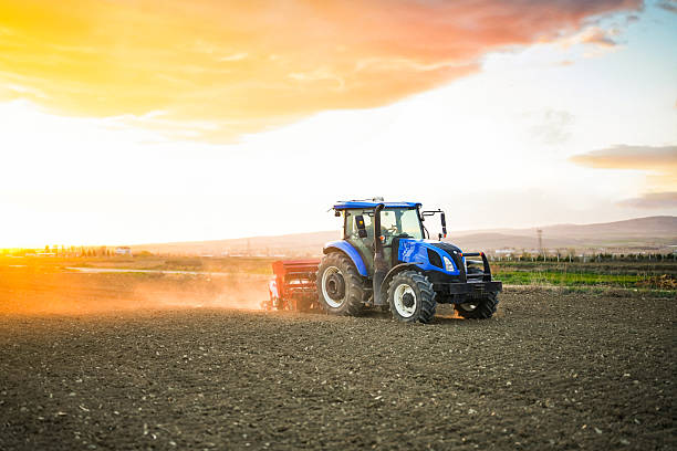 istock A farmer sowing seeds with a tractor and seed drill in a field at sunset 2212782804