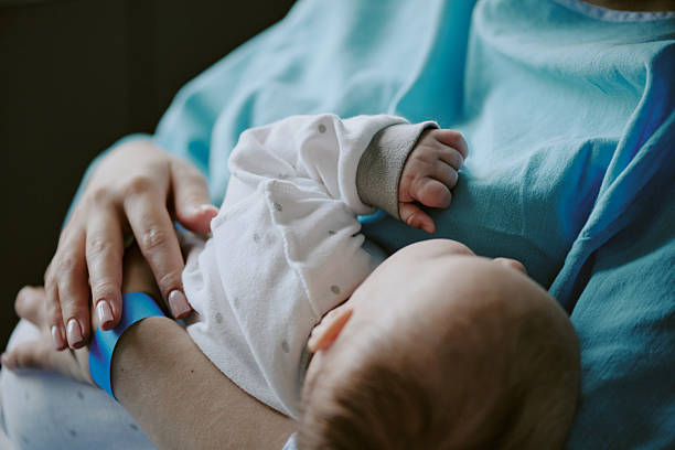 istock Mother Breastfeeding Baby in Soft Lighting Environment 2212787486