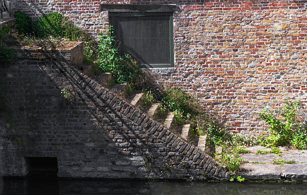 istock A solid brick wall featuring a window and stairs leading up to it 2212788756