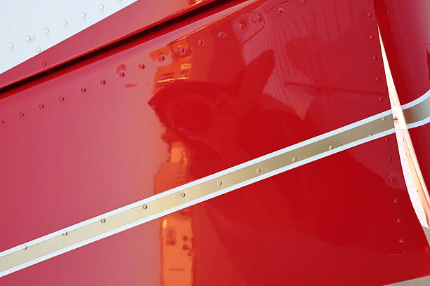 The bolting pattern on the wing of a small airplane parked on the runway.