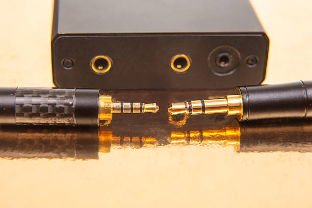 istock Two gold-plated 3.5mm audio jacks on a reflective gold backdrop, highlighting audio connectivity and tech details. Suitable for music and tech stock photography. 2212792177