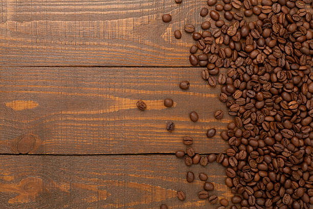 istock Roasted coffee beans with leaves on wooden background,top view 2212793642