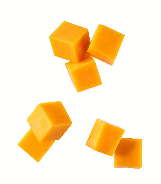 istock falling cheddar cheese sliced ​​into cubes isolated on white background, top view. 2212796903