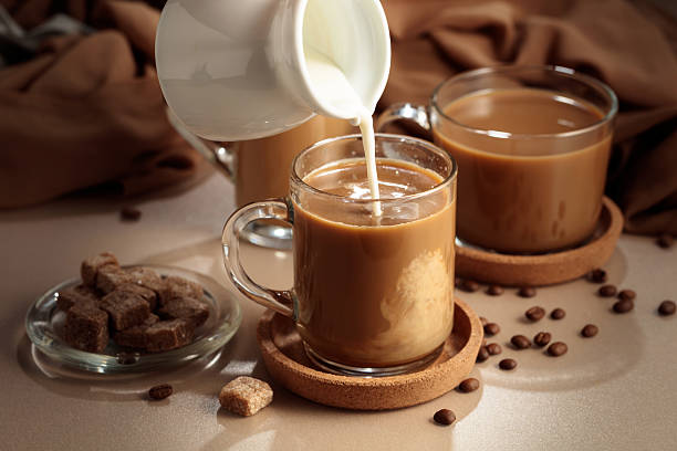 istock Pouring cream in black coffee. 2212799094