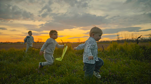 istock Children Running in the Field at Sunset 2212804333