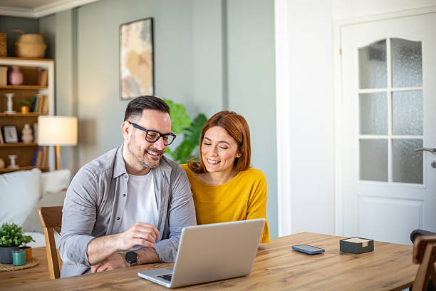 istock Happy couple watching something on laptop at home 2212808130