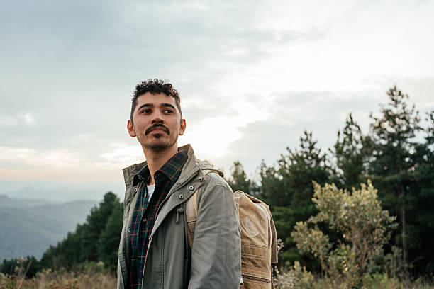 Young adventurous man walking on mountain trail