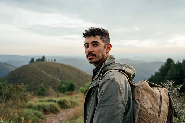 Young adventurous man walking on mountain trail