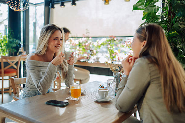 istock Two young women enjoying coffee and conversation in a cafe 2212809191