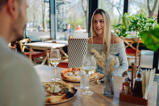 istock Young couple enjoying pizza and wine at a restaurant 2212809210
