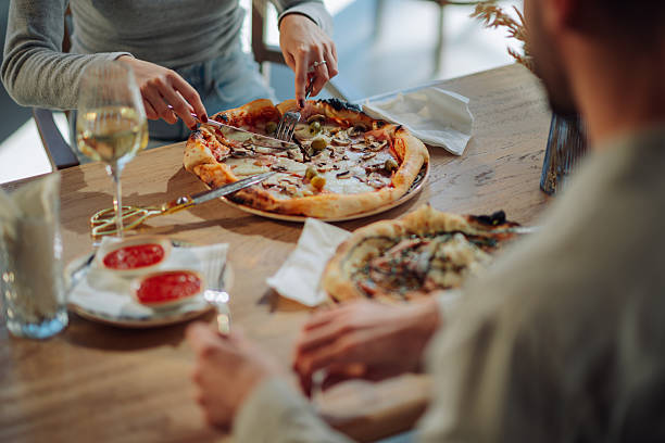 istock Couple enjoying pizza and wine at restaurant table 2212809218