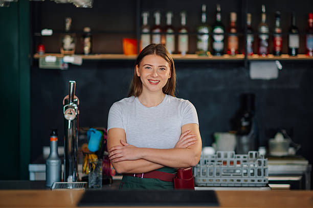 istock Young caucasian bartender smiling with crossed arms behind bar counter 2212809267