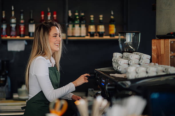 istock Smiling barista preparing coffee in a modern cafe 2212809280