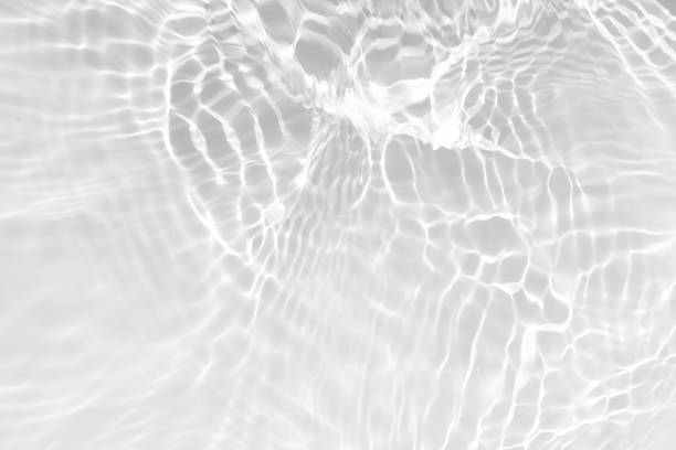 istock White water with ripples on the surface. Defocus blurred transparent white colored clear calm water surface texture with splashes and bubbles. Water waves with shining pattern texture background. 2212811413