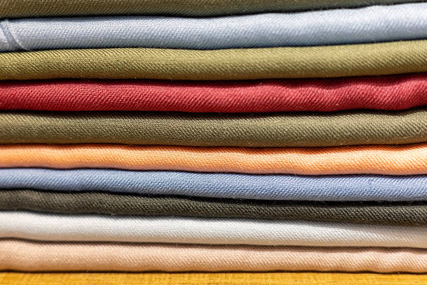 istock Colorful stack of neatly folded fabric showcasing various textures and hues in a home sewing space 2212811574