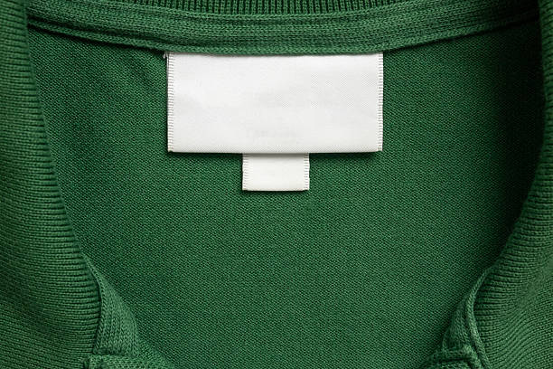 istock Blank white laundry care clothes label on green shirt fabric texture background 2212811616