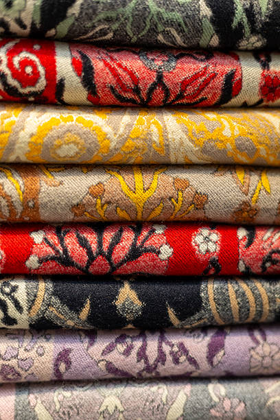 istock Fabric designs feature intricate floral patterns and vibrant colors, displayed in a stacked arrangement at a textile market 2212811669
