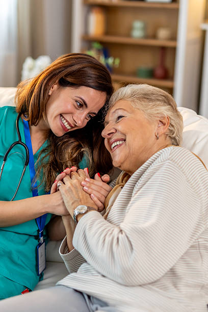 istock Caring Nurse Holding Elderly Woman's Hands in a Comforting Home Environment 2212812256
