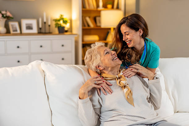 istock Happy Caregiver Supporting Elderly Woman at Home With Kind Interaction 2212812265