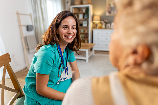istock Smiling Female Nurse Interacting with Senior Patient in Comfortable Home Environment 2212812277