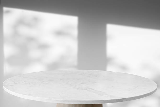 istock Round marble table top with tree leaves shadow drop on white wall background for mockup product display 2212812578