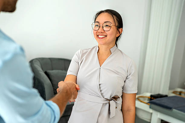 istock Professional Woman Greeting a Business Associate with a Handshake 2212814611