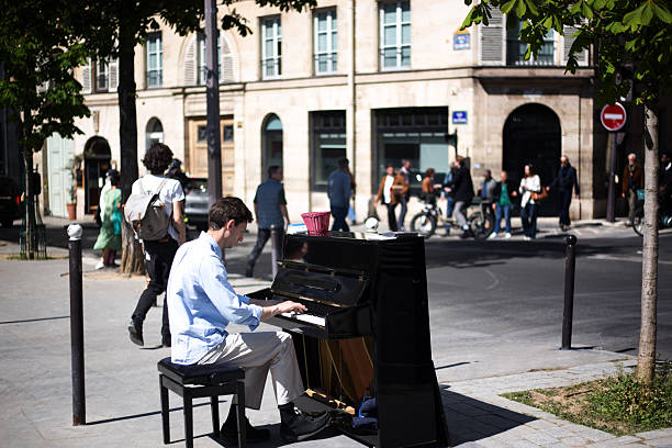 Paris, France: A pianist playing an upright piano outside on a sidewalk on Rue de Vaugirard (6th arrondissement).
