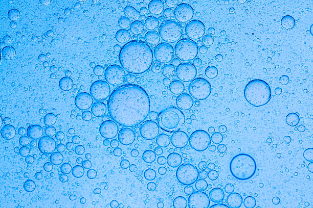 istock Macro blue science experiment bubble texture,A close-up of a blue liquid with bubbles in a petri dish, showcasing a captivating microscopic view. ideal for concepts of science, medicine, research, and experimentation. 2212819021