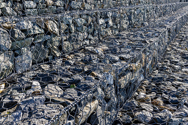 Urban decoration with rocks in a metal mesh on the promenade.