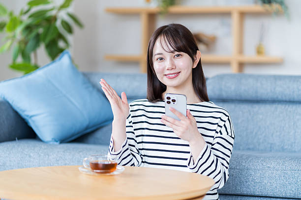 istock Young woman using smartphone in living room 2212822878