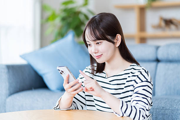 istock Young woman using smartphone in living room 2212822922
