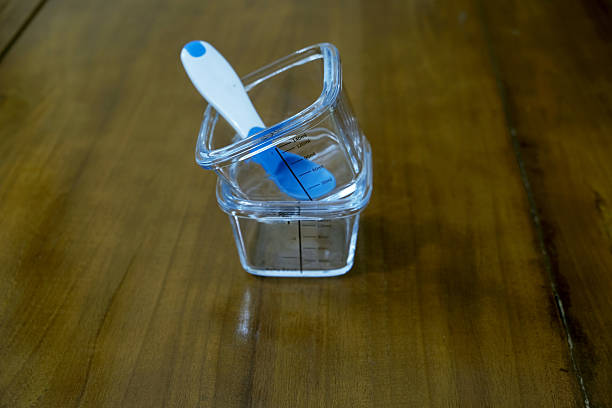 Glass bowl and spoon rubber. Baby tableware on wooden table background. Serving baby food, kid dishware. First baby food concept