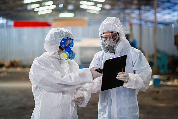 istock Two people in white protective gear are looking at a clipboard 2212833285