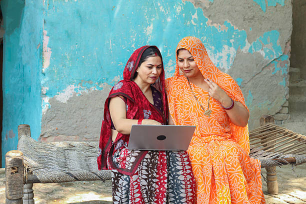Rural indian women using laptop or learning computer together. Digital india. Wireless technology.