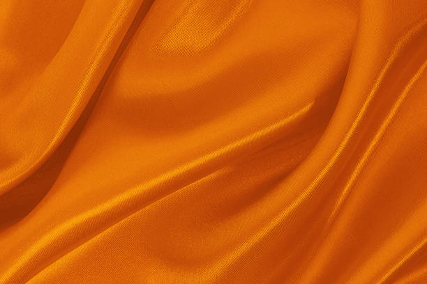 Orange fabric texture background, detail of silk or linen pattern.