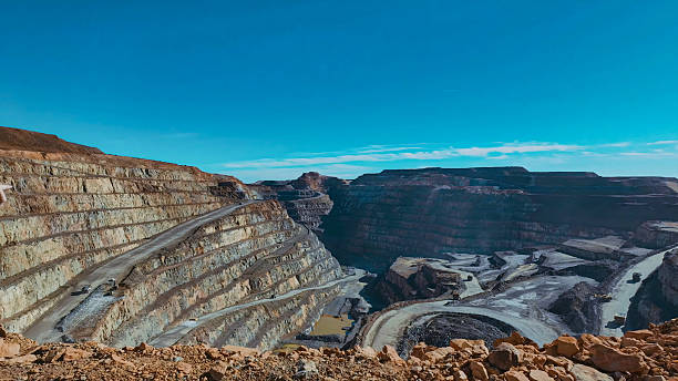 istock Panoramic view of the main pit of an open pit mine with machinery extracting minerals 2212845334