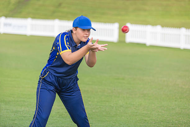 Teenage girls practicing playing cricket