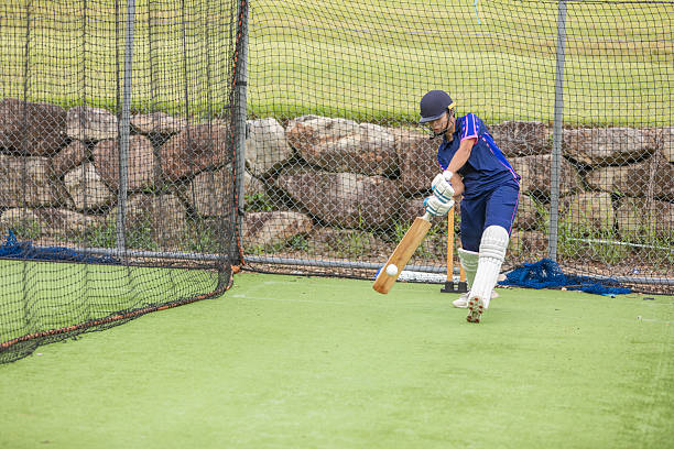Teenage girls practicing playing cricket