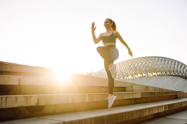 istock Young woman in sportswear doing exercises on steps at sunset. 2212849638