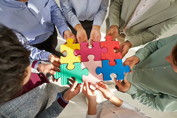 istock Group of business people assembling jigsaw puzzle, cropped shot 2212849741