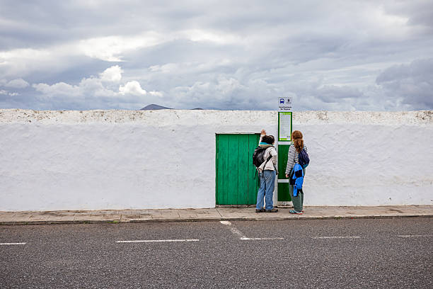 White architecture, palm trees and traffic signs. High tower of a church Iglesia de Nuestra Senora de Guadalupe. Bright blue sky . Teguise, Lanzarote, Canary Islands, Spain.