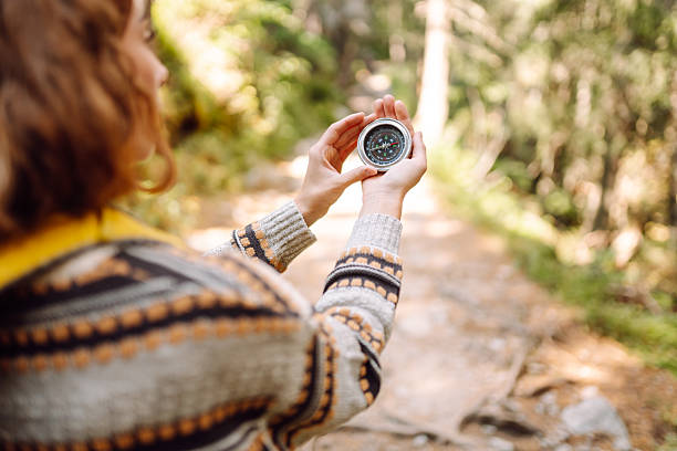 istock A back view of a female hiker with a backpack and a compass on a hiking forest path in the rays of the sunset. 2212850124